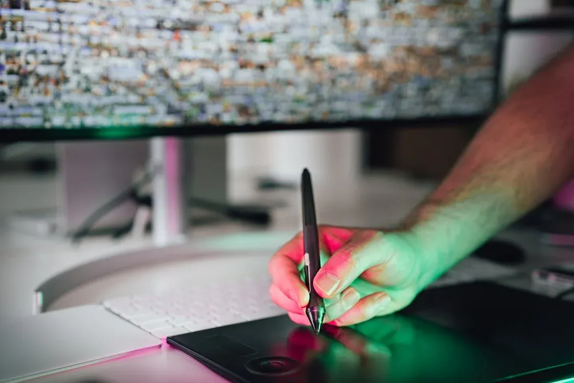 artist using stylus on graphics tablet while working on vector design