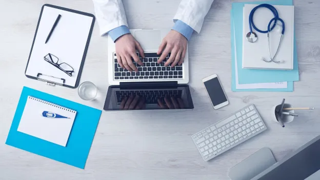 a doctor prepared for an online consultation, typing on a laptop