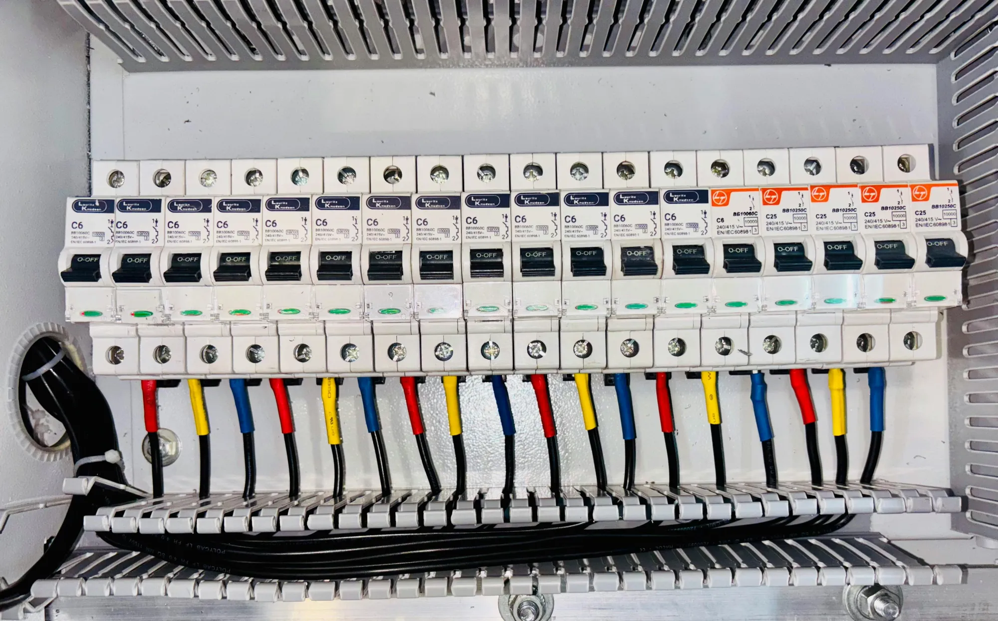 Organized circuit breaker panel with color-coded electrical wiring