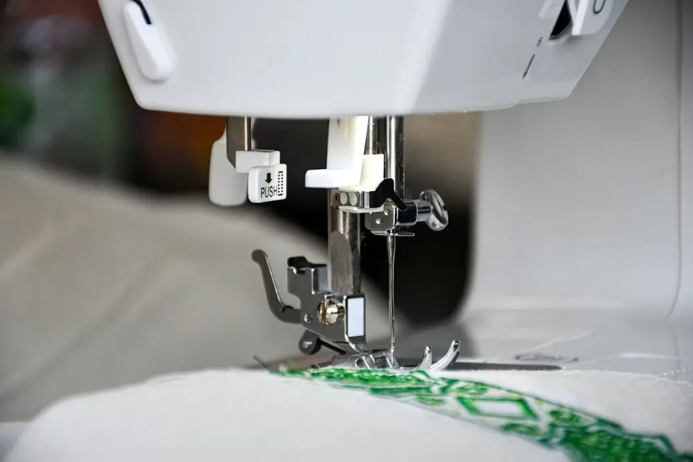 A machine embroidering a cloth in green