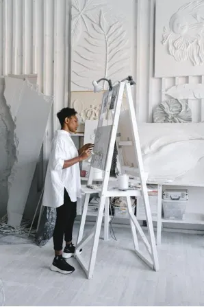 Black woman painting artwork inside an art gallery