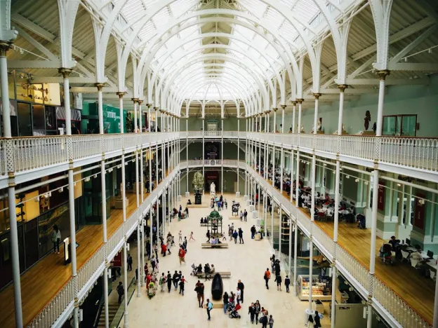 Museum interior with visitors walking through galleries and viewing artworks