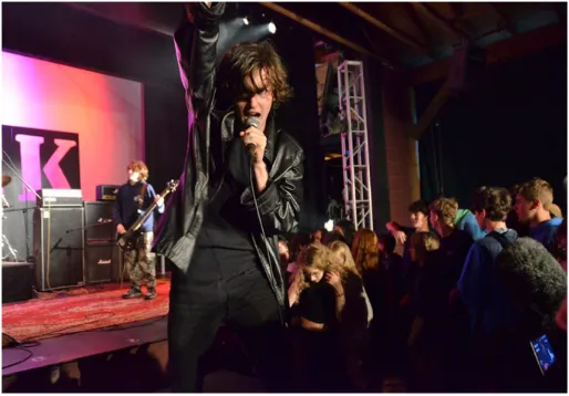 A camper singing into a microphone during a live rock night performance
