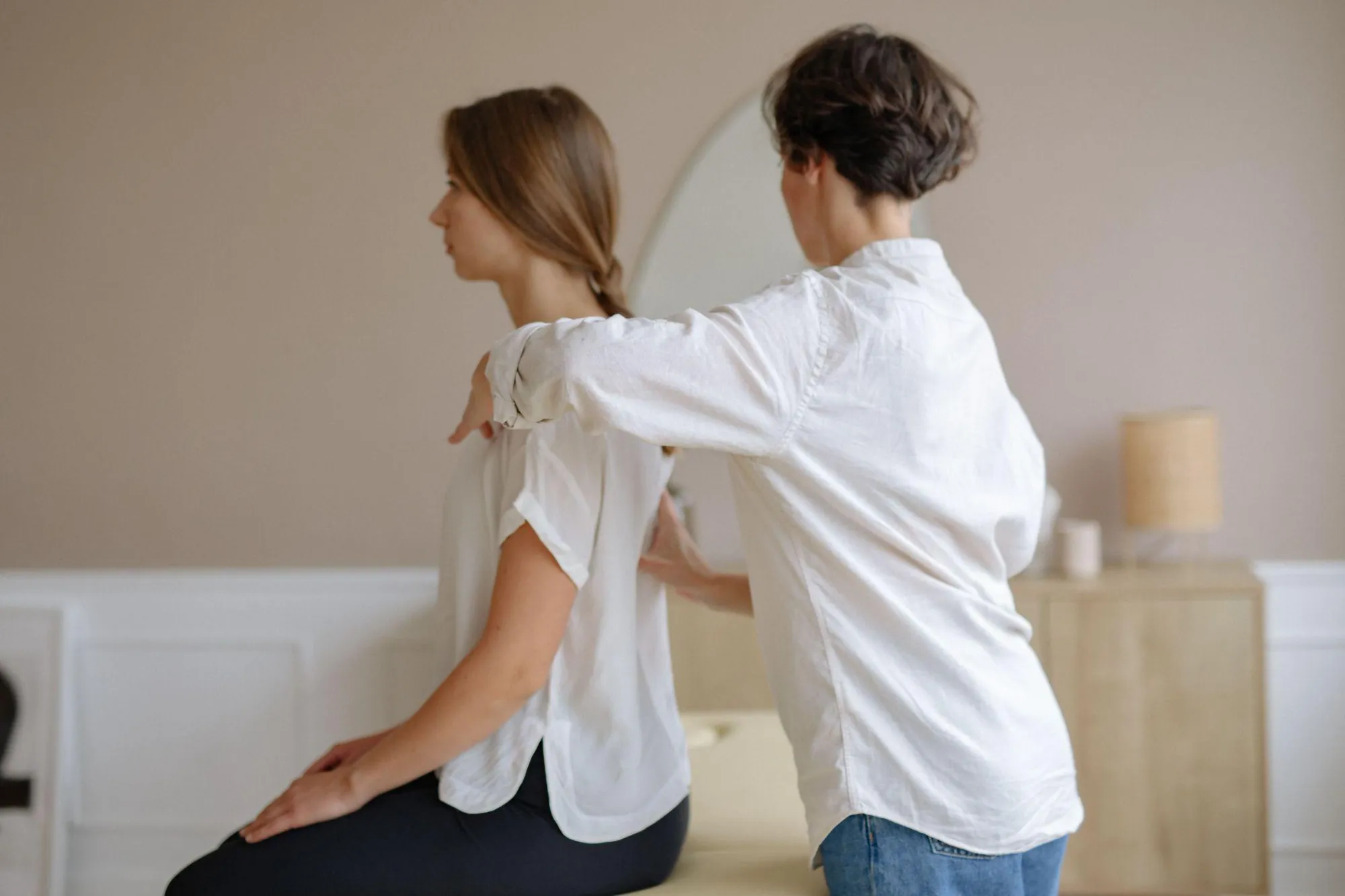 a massage therapist massaging a client’s back