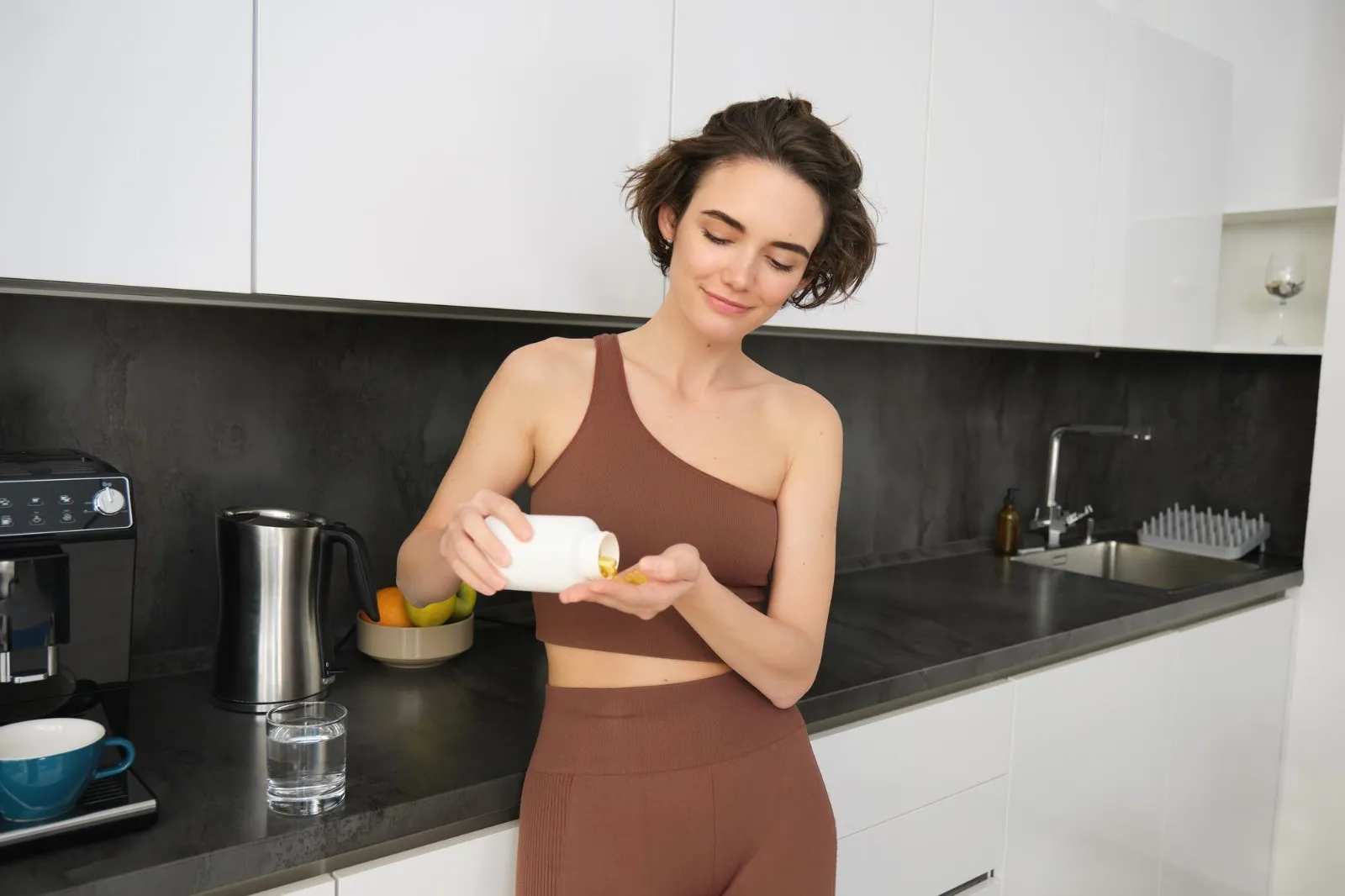 Woman taking a nattokinase supplement at home as part of her daily wellness routine, supporting a healthy lifestyle.