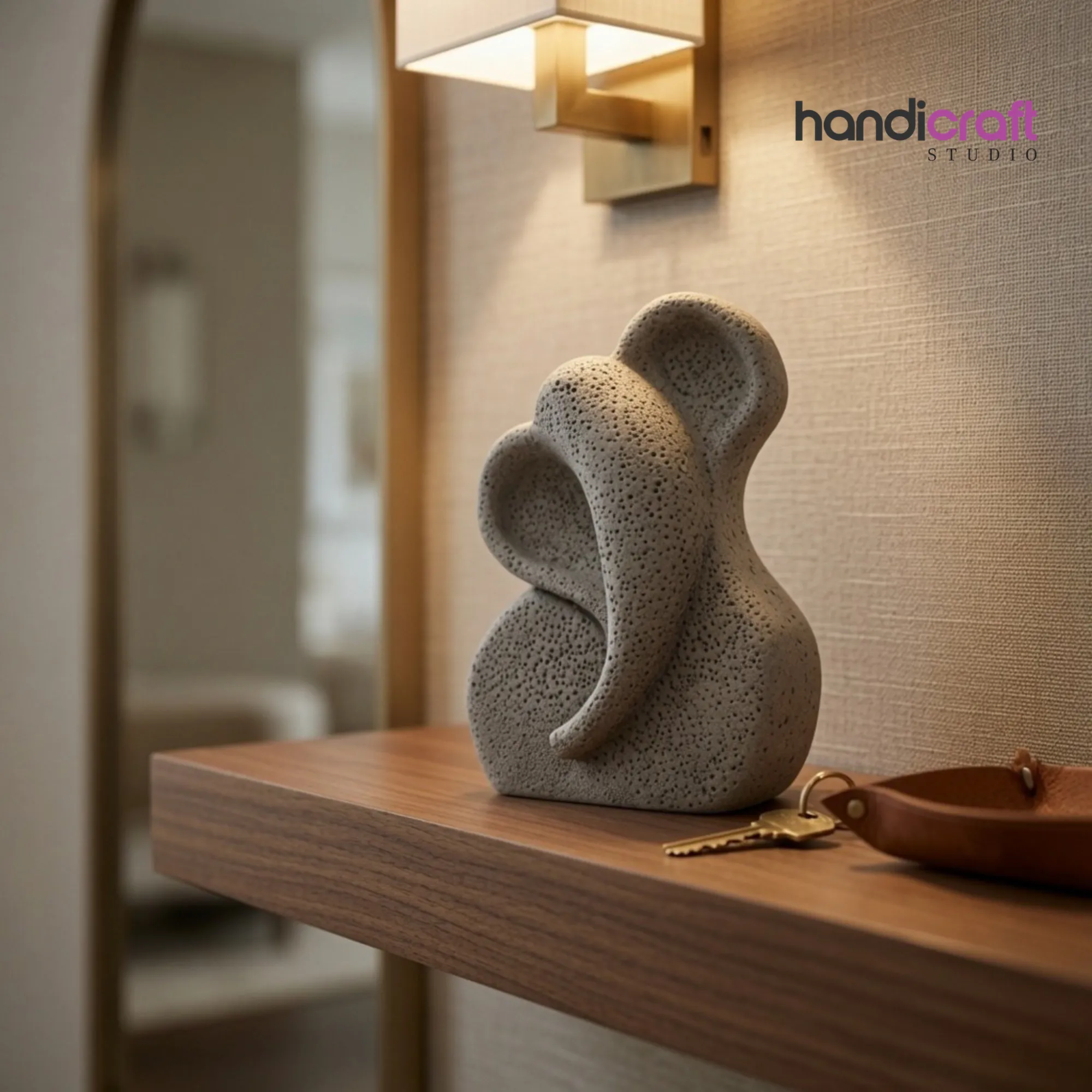 Minimalist grey ceramic Ganesha idol styled on a modern living room wooden console table.