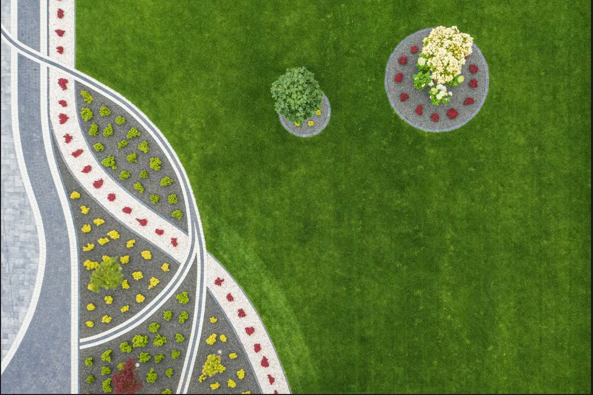 Overhead view of a modern landscaped lawn with paved pathways and decorative plant beds.