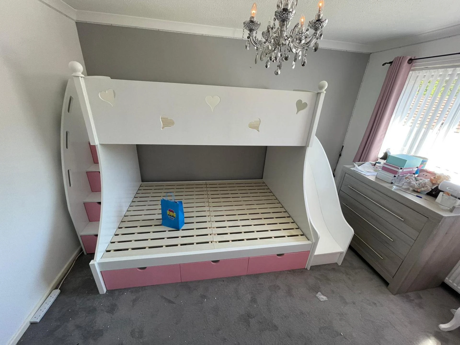 A triple bunk bed with slide offers a safe way for children