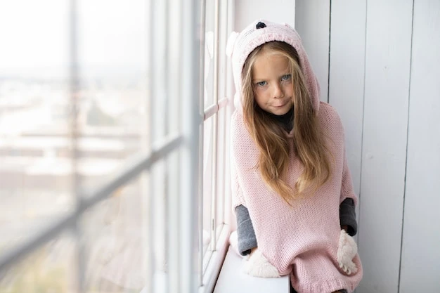 Little girl posing next to a window