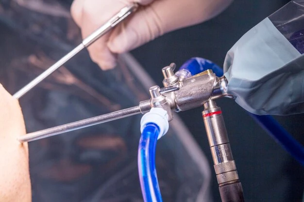 Midsection of doctors performing surgery on patient knee with equipment