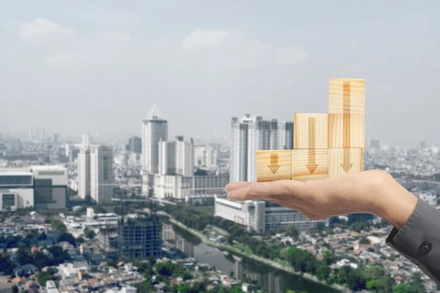 Hand holding stack of wooden block toy with down arrow with cityscape background