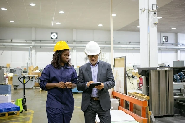 Manager discussing factory work with worker