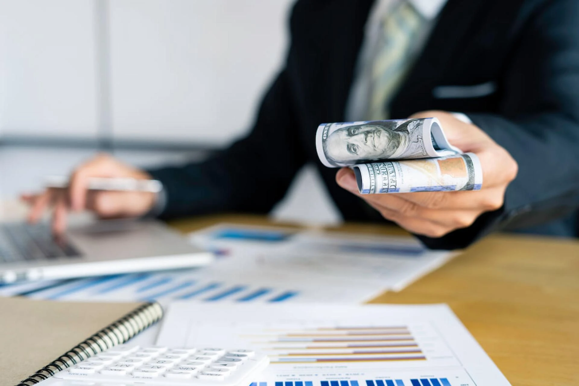 Timeshare cost: person using a calculator while handing out cash