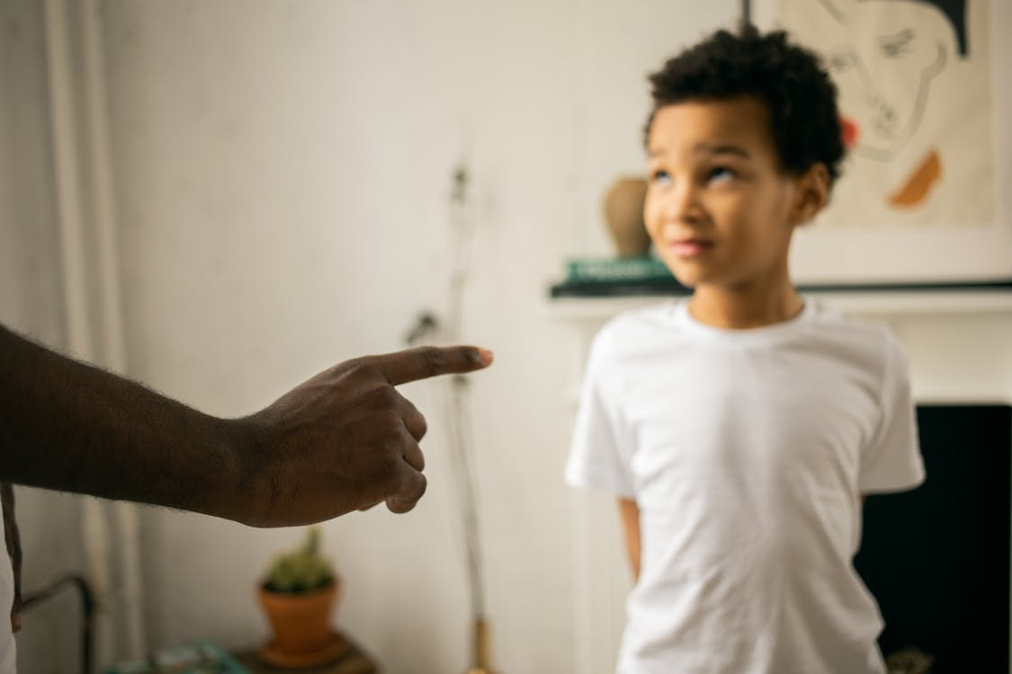a little boy upset being scolded by his father