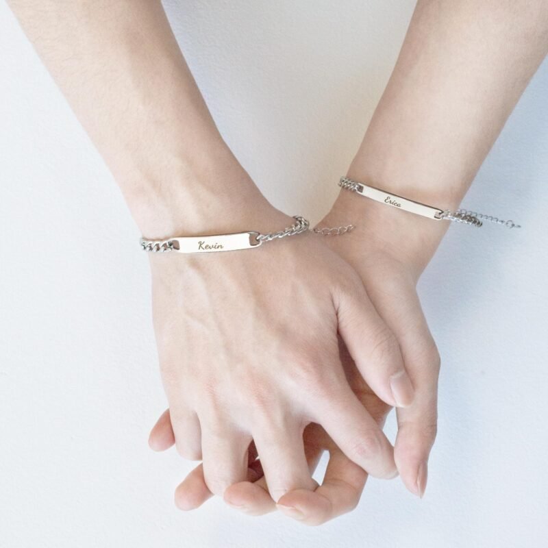 two hands holding each other with name traced bracelet as showing there valentines day gifts
