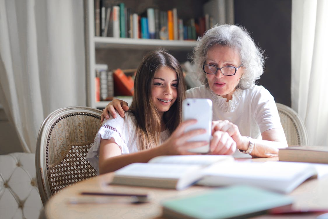 Woman showing a smartphone screen to an elderly woman