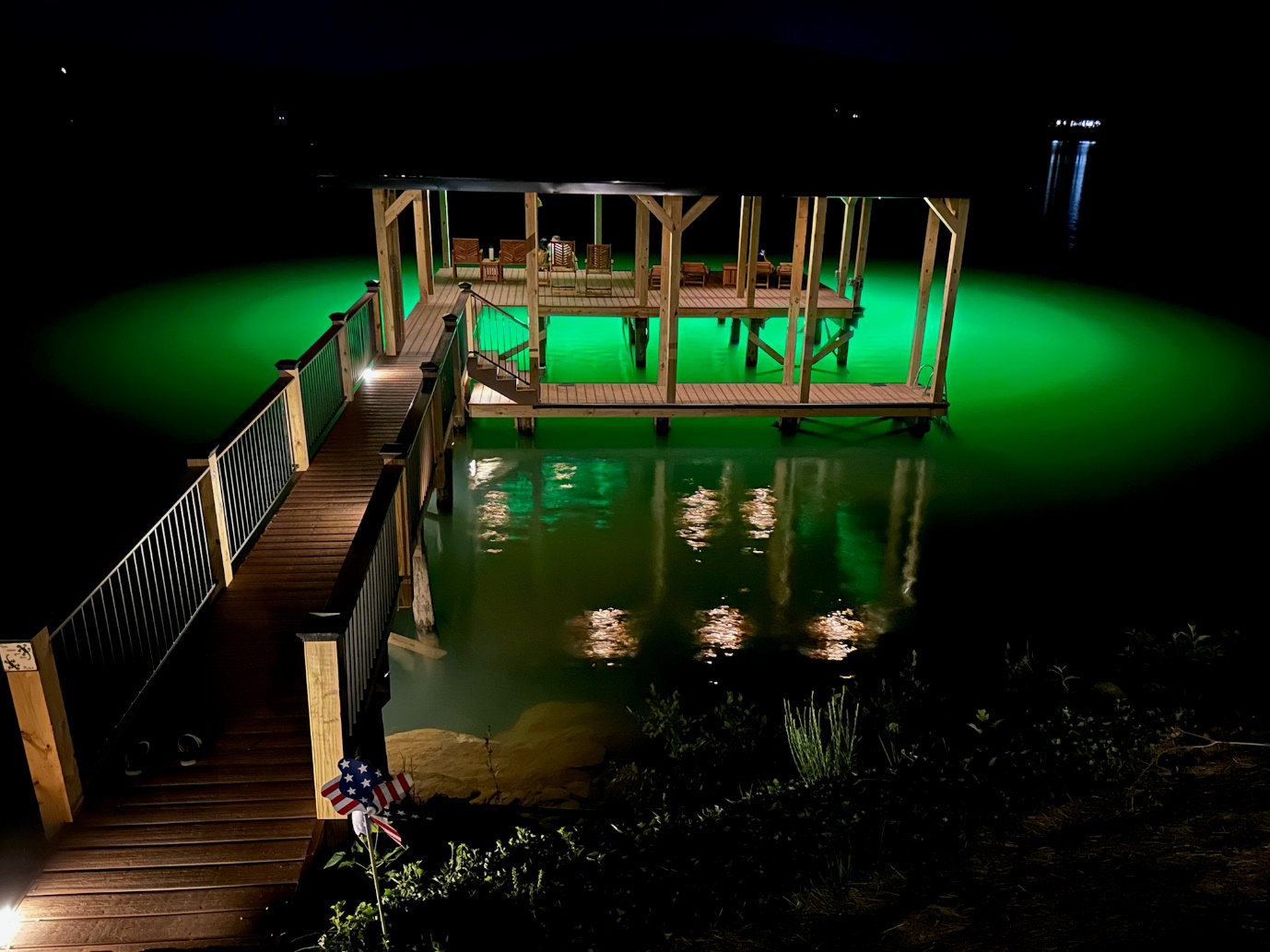 A dock illuminated by underwater green light