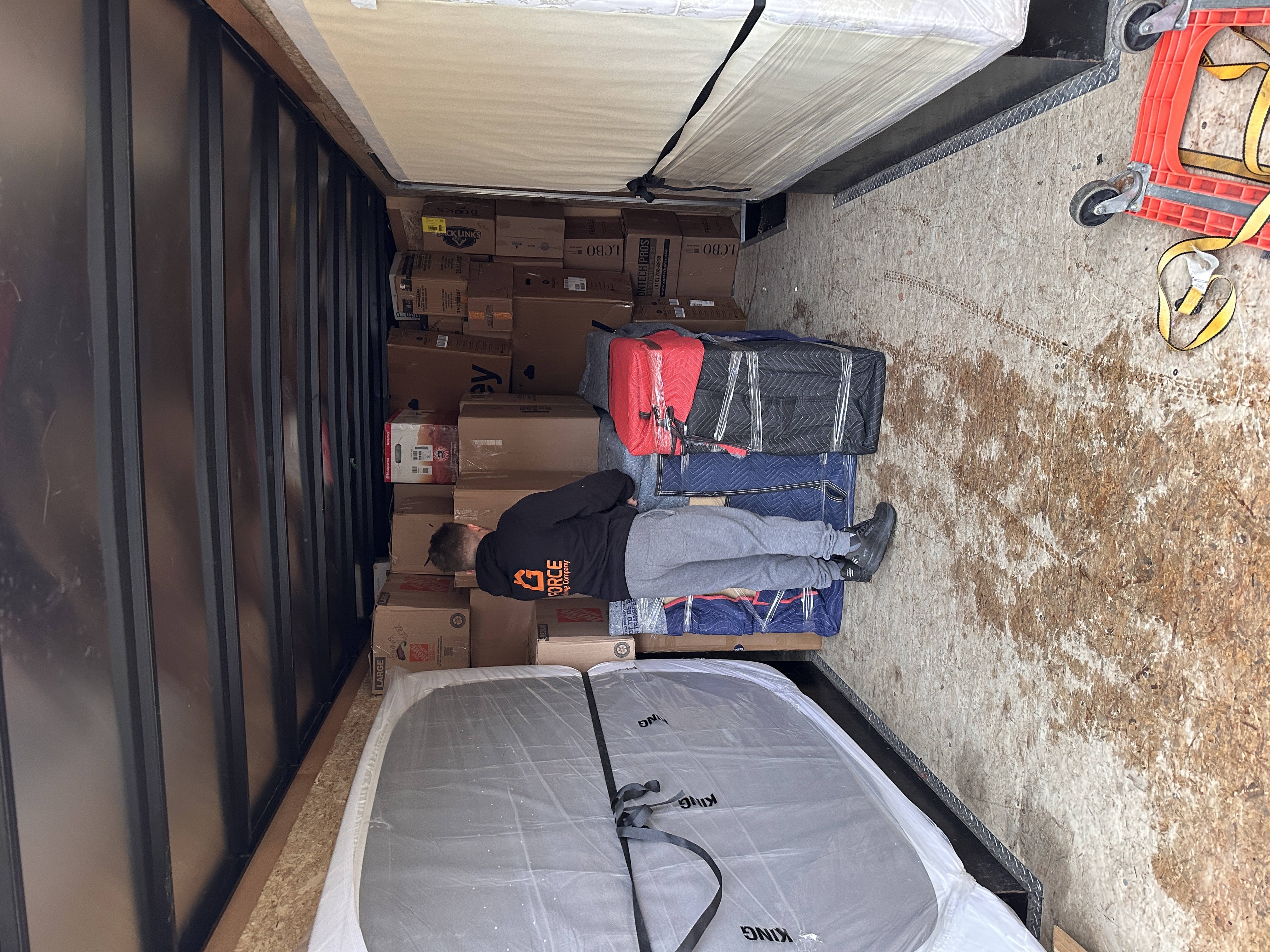 Movers loading boxes and furniture into a moving trailer.