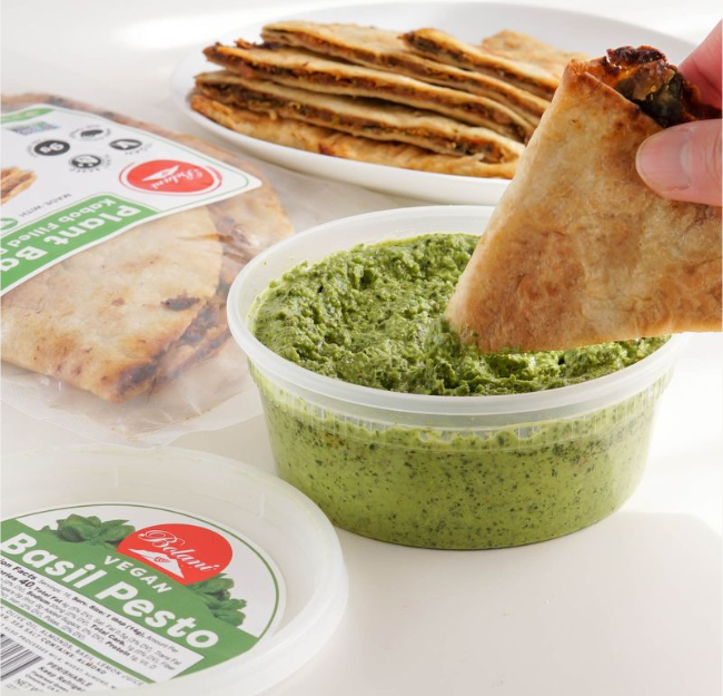 A person dipping their flatbread in chutney. 