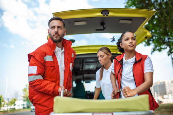 A team of EMTs rolling a stretcher out of an ambulance