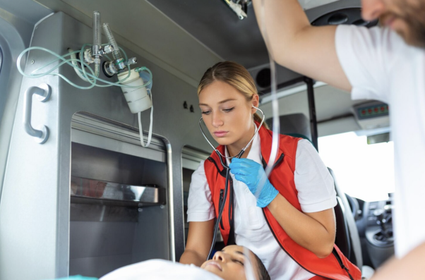 An EMT attending to a patient inside an ambulance while monitoring vital signs