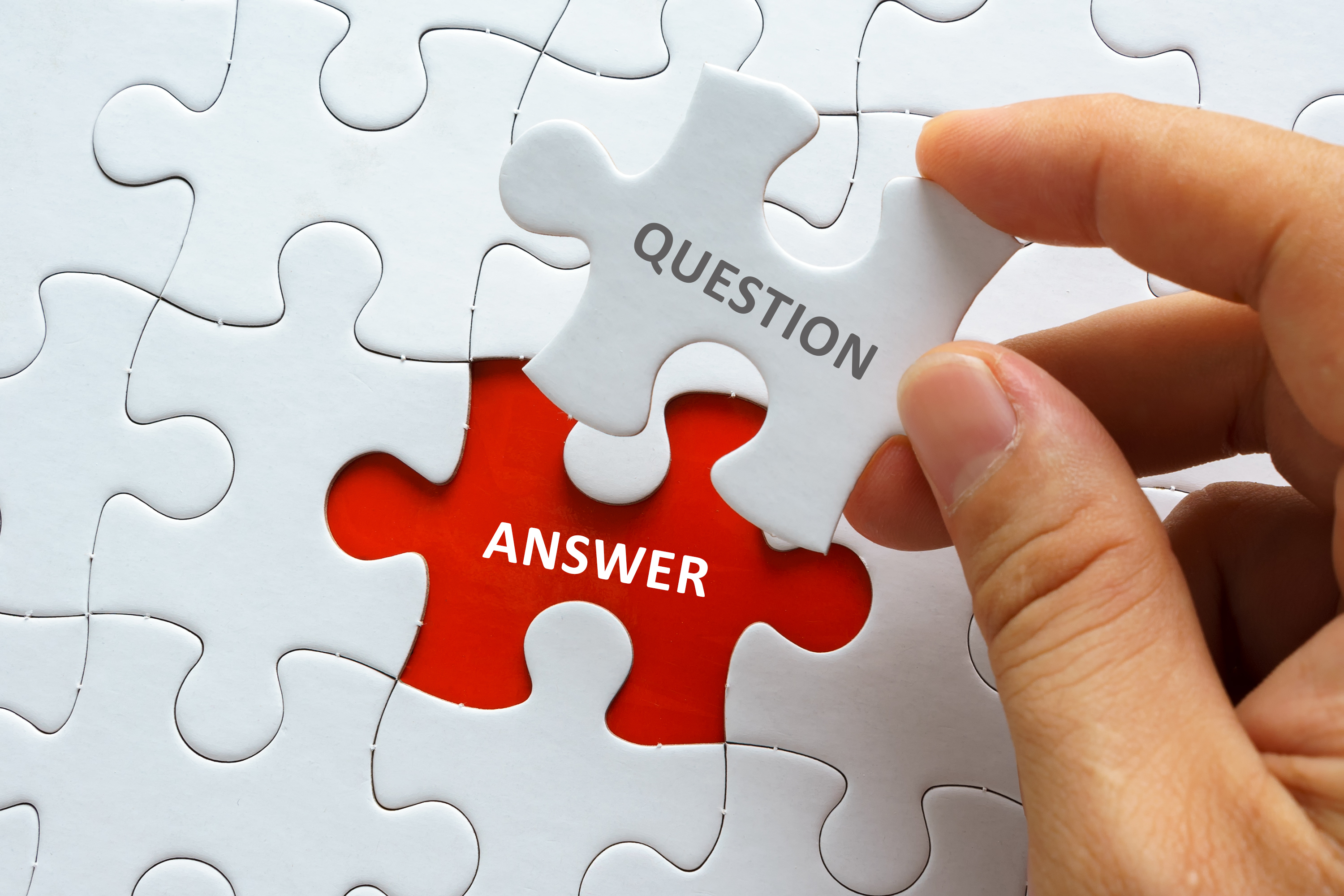 A hand places a puzzle piece labeled 'QUESTION' into a red puzzle spot labeled 'ANSWER'.