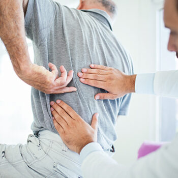 doctor_looking_at_patients_back_pain-0309b491