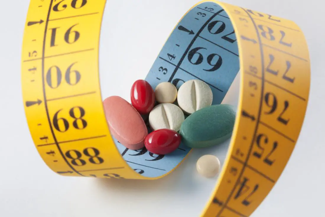 weight-loss-and-diet-pills-surrounded-by-measuring-tape-0205951f
