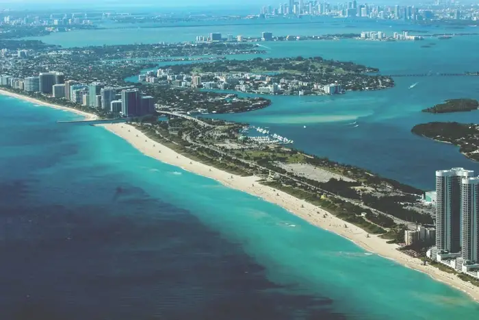 An aerial view of Miami's skyline, including the beach and greenery.