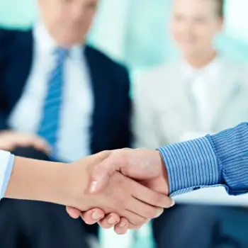 handshake-with-businesspeople-blurred-background-409889d8