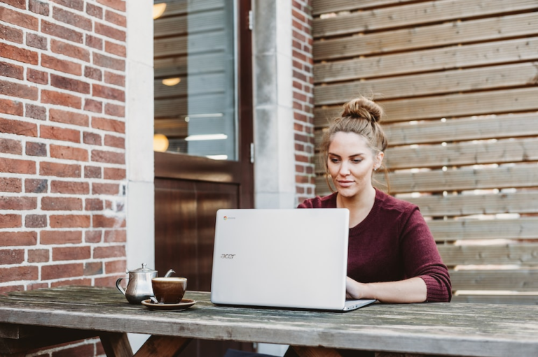 Woman using laptop in her backyard