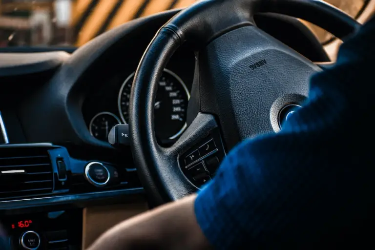  a person wearing a blue shirt while driving a car