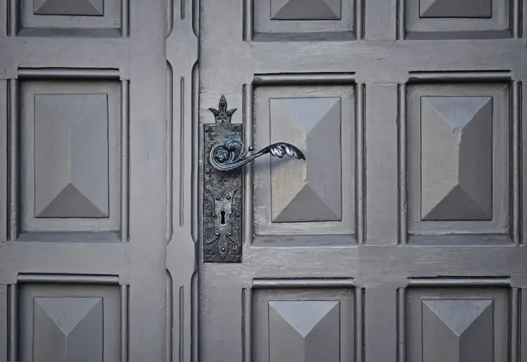 an antique lock on a grey door