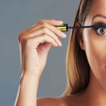Lady applying mascara on lashes