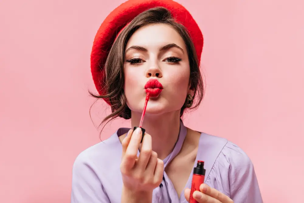 portrait-young-girl-red-beret-painting-her-lips-with-bright-lipstick-pink-background