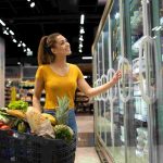 female-person-with-shopping-cart-taking-frozen-food-from-fridge-grocery-store (1)