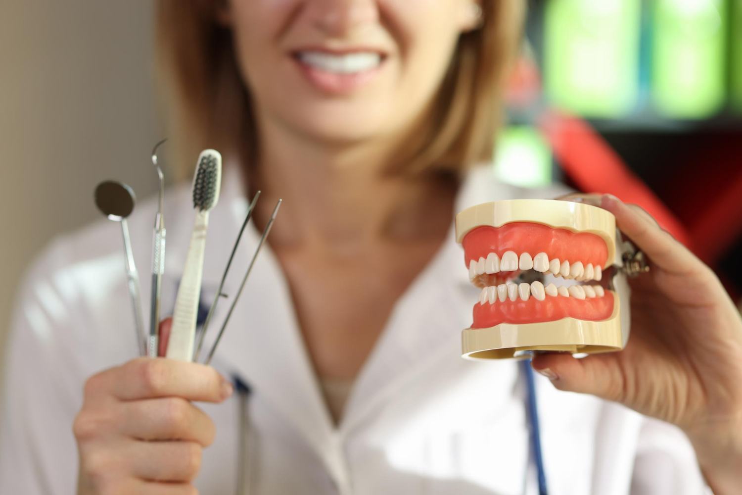 positive-dentist-holds-teeth-care-tools-human-jaws-model-clinic-office-doctor-presents (1)