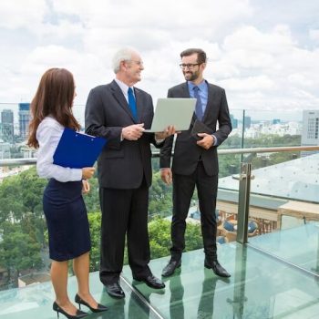 senior advisor man with a laptop talking to two other