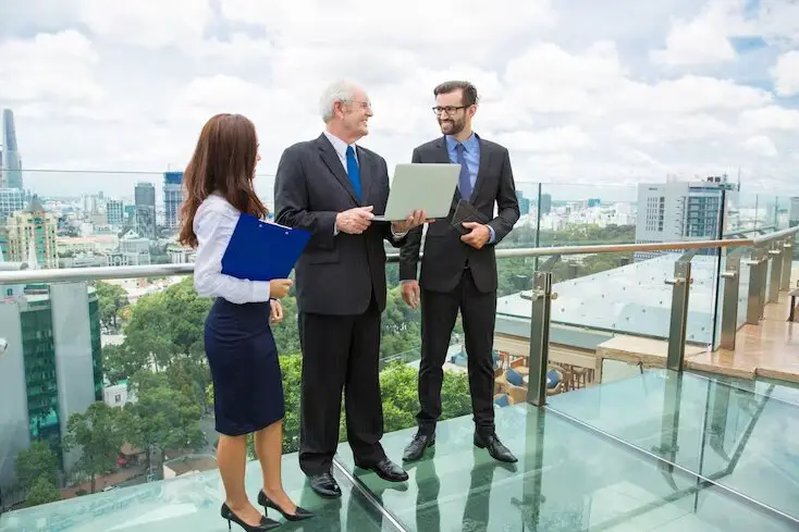 senior advisor man with a laptop talking to two other