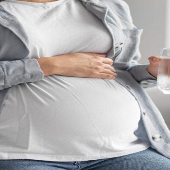 pregnant-woman-home-holding-glass-water-696x418