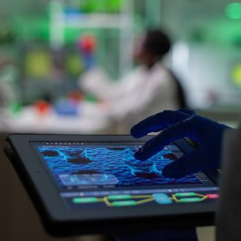 scientist-researcher-doctor-analyzing-genetic-mutation-test-using-tablet-while-her-collegue-typing-biological-expertise-computer