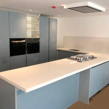 U-shaped Handleless Kitchen With Corian Worktops in Finchley