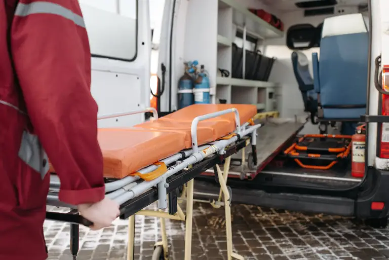 An Emergency First Responder Rolling a Stretcher Out of an Ambulance