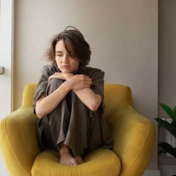 Photo full shot woman with anxiety sitting on chair