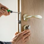 carpenter-repairs-door-lock-installation-door-handle-with-tool_8119-2109