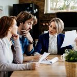 financial-advisor-communicating-with-young-couple-while-going-through-their-financial-reports-during-meeting-home