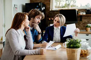 financial-advisor-communicating-with-young-couple-while-going-through-their-financial-reports-during-meeting-home