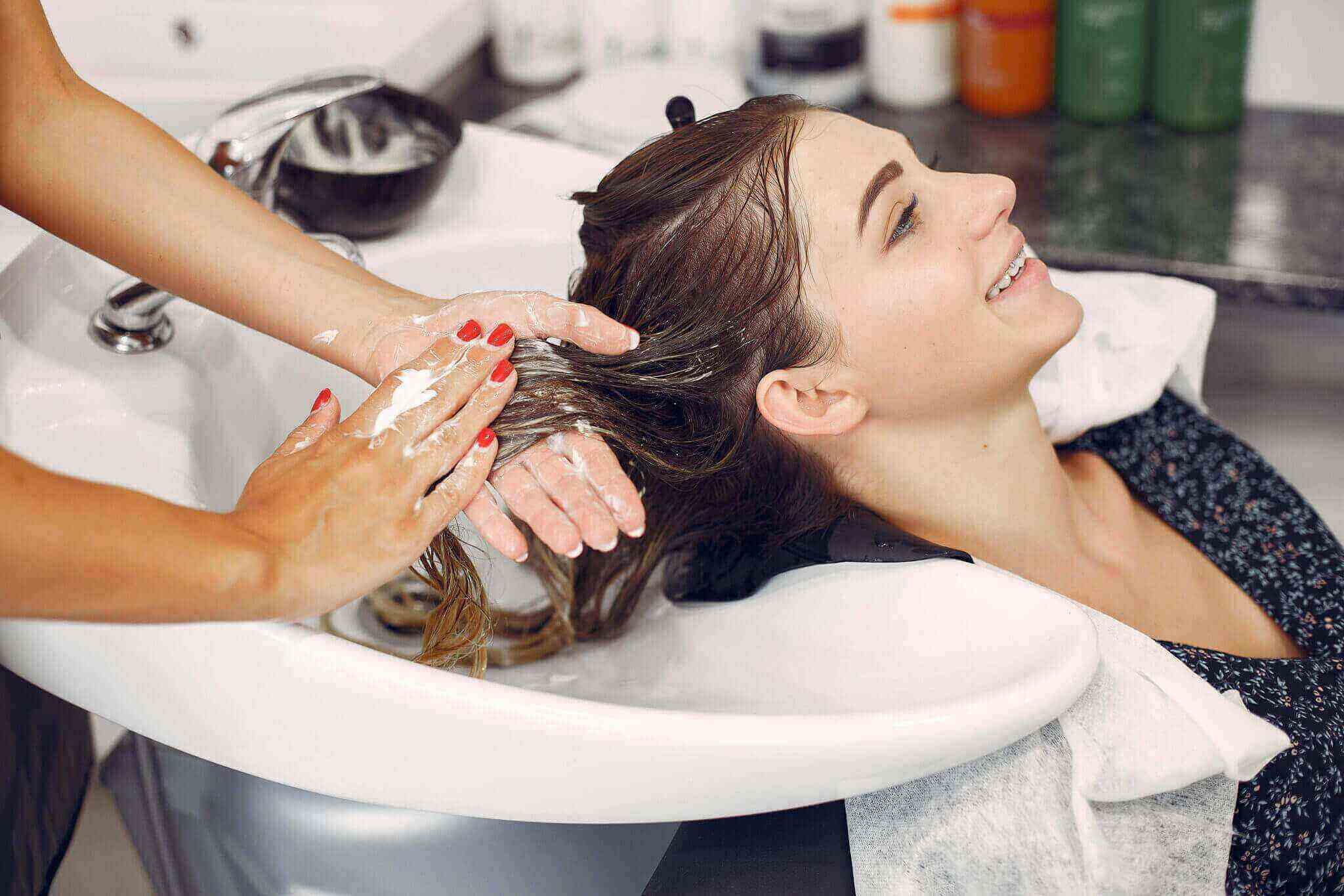 woman-washing-head-hairsalon-scaled