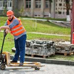 brutal-beard-worker-man-suit-construction-worker-safety-orange-helmet-with-pallet-truck (1)