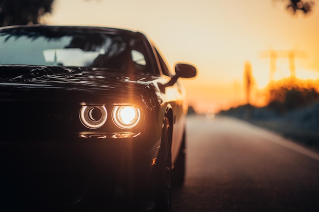 luxurious-car-parked-highway-with-illuminated-headlight-sunset_181624-60607